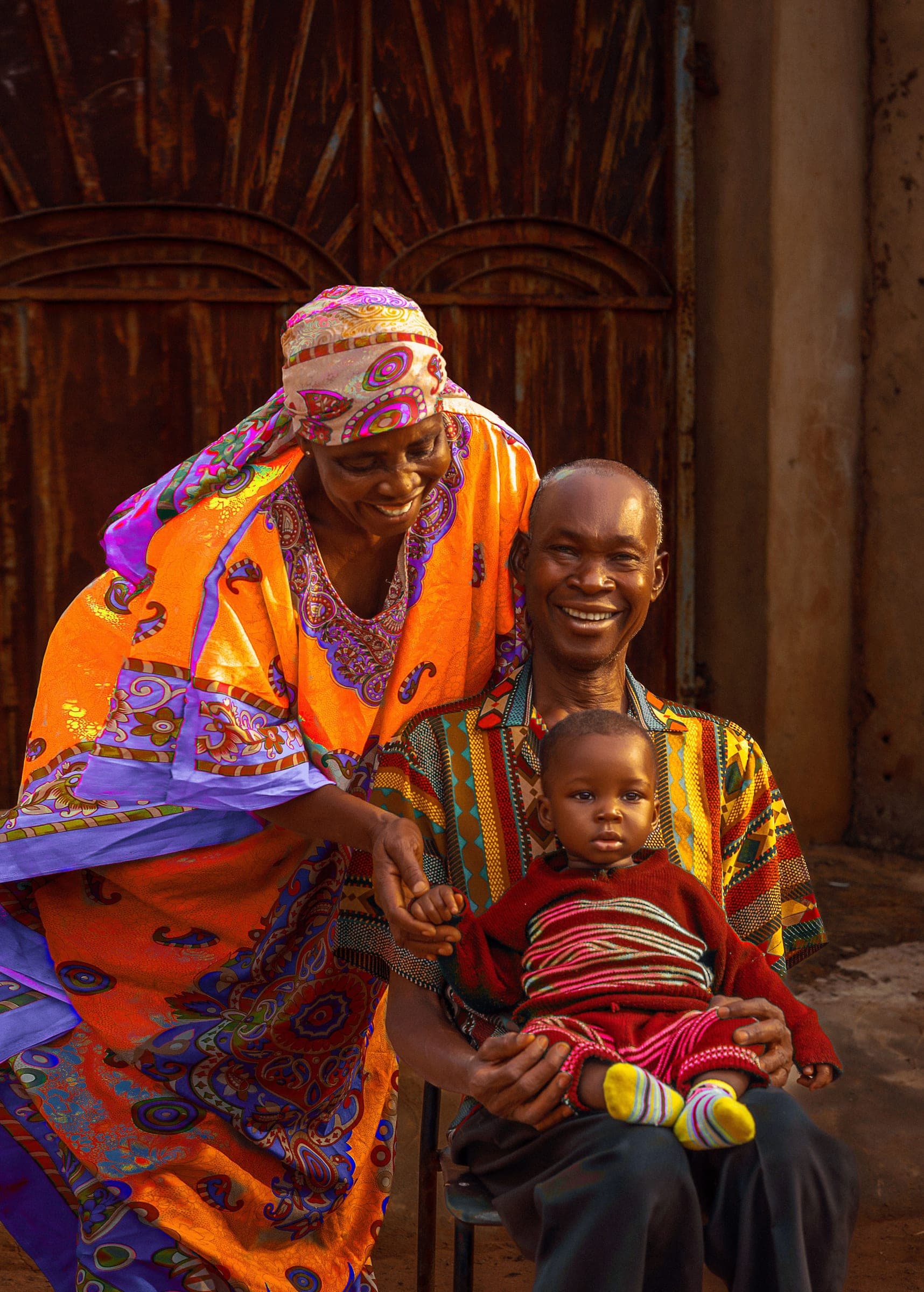 Smiling grandparents sitting together with their grandchild