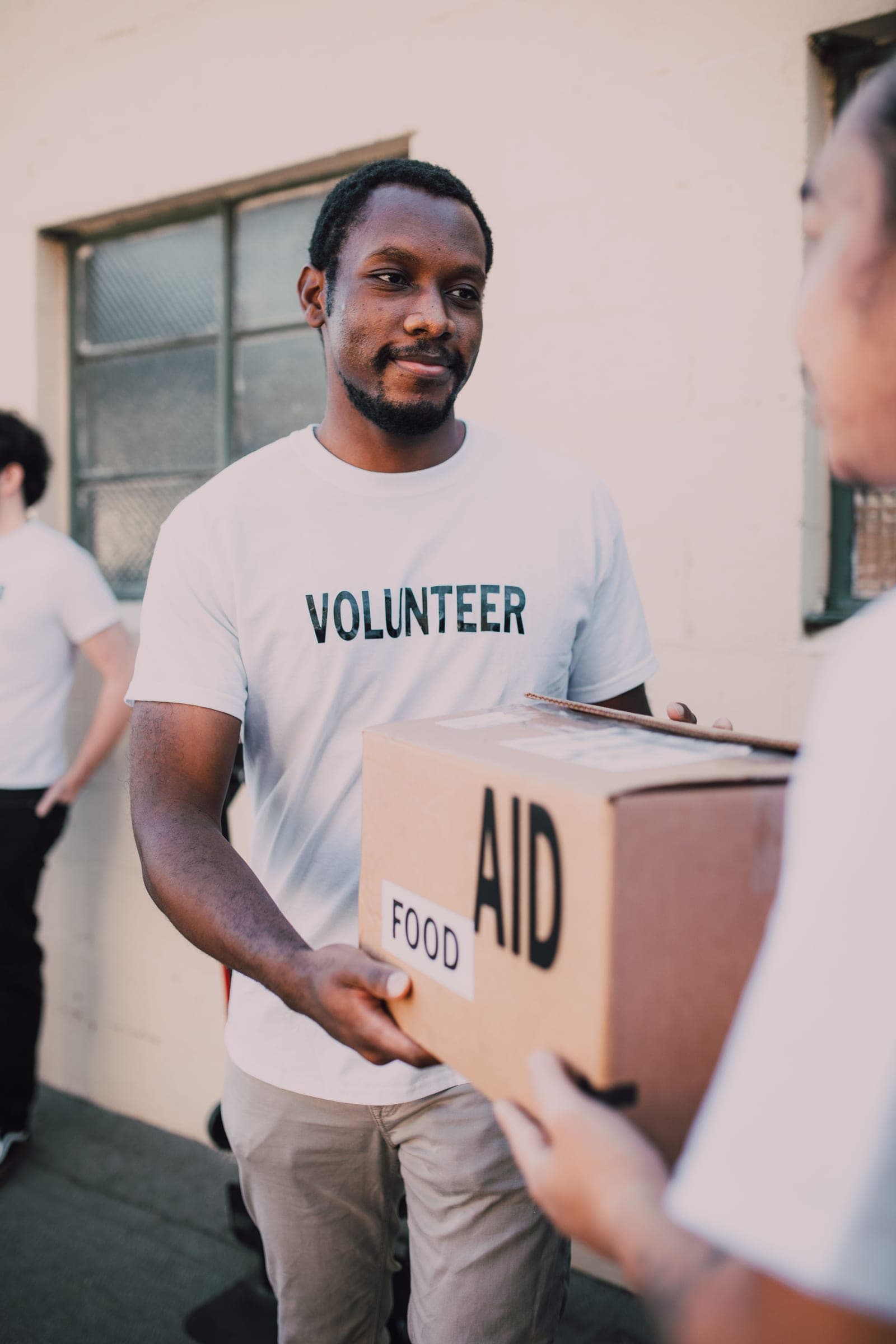 A volunteer handing over a box of food aid