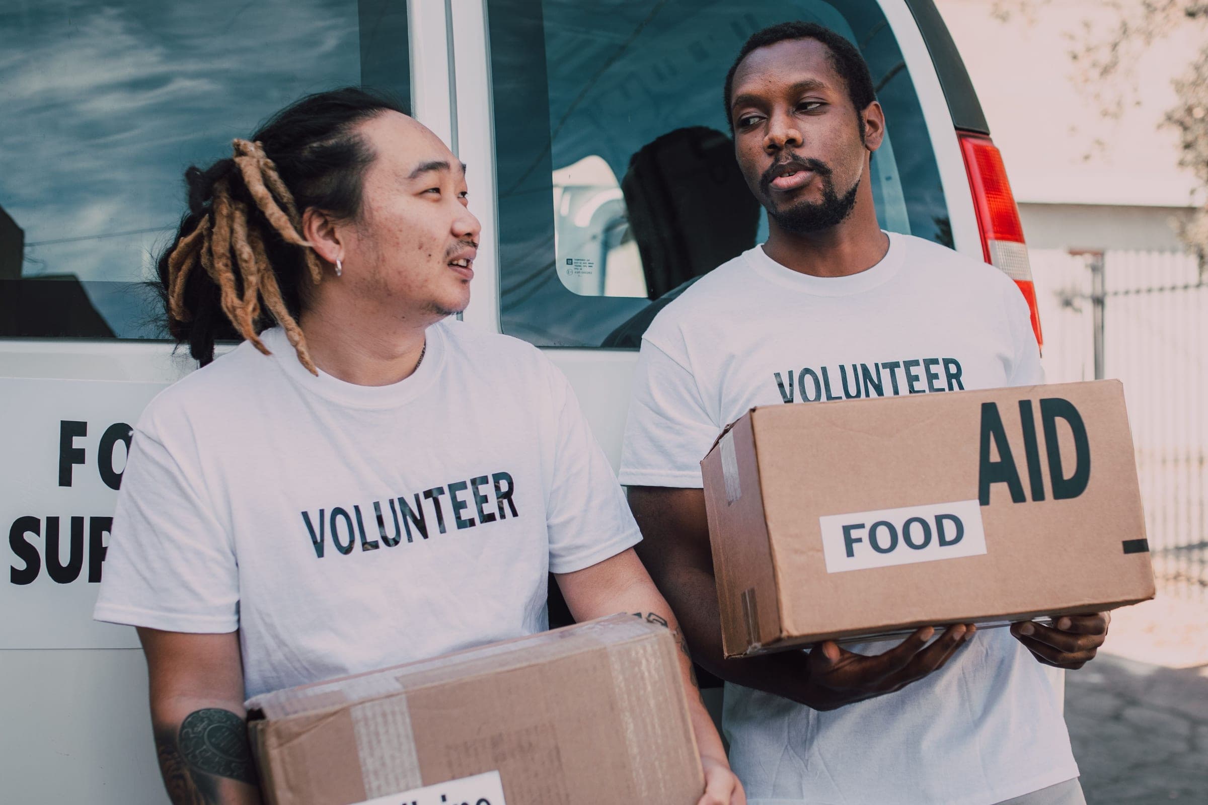 Two volunteers holding boxes of food aid