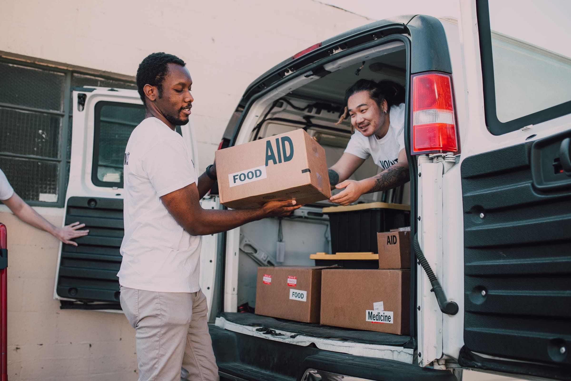 Volunteers loading boxes of food and medicine into a van