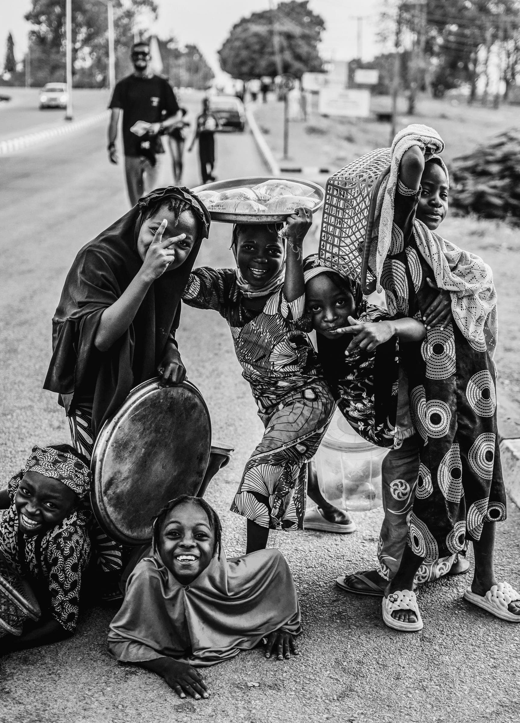 A group of laughing children posing by the roadside