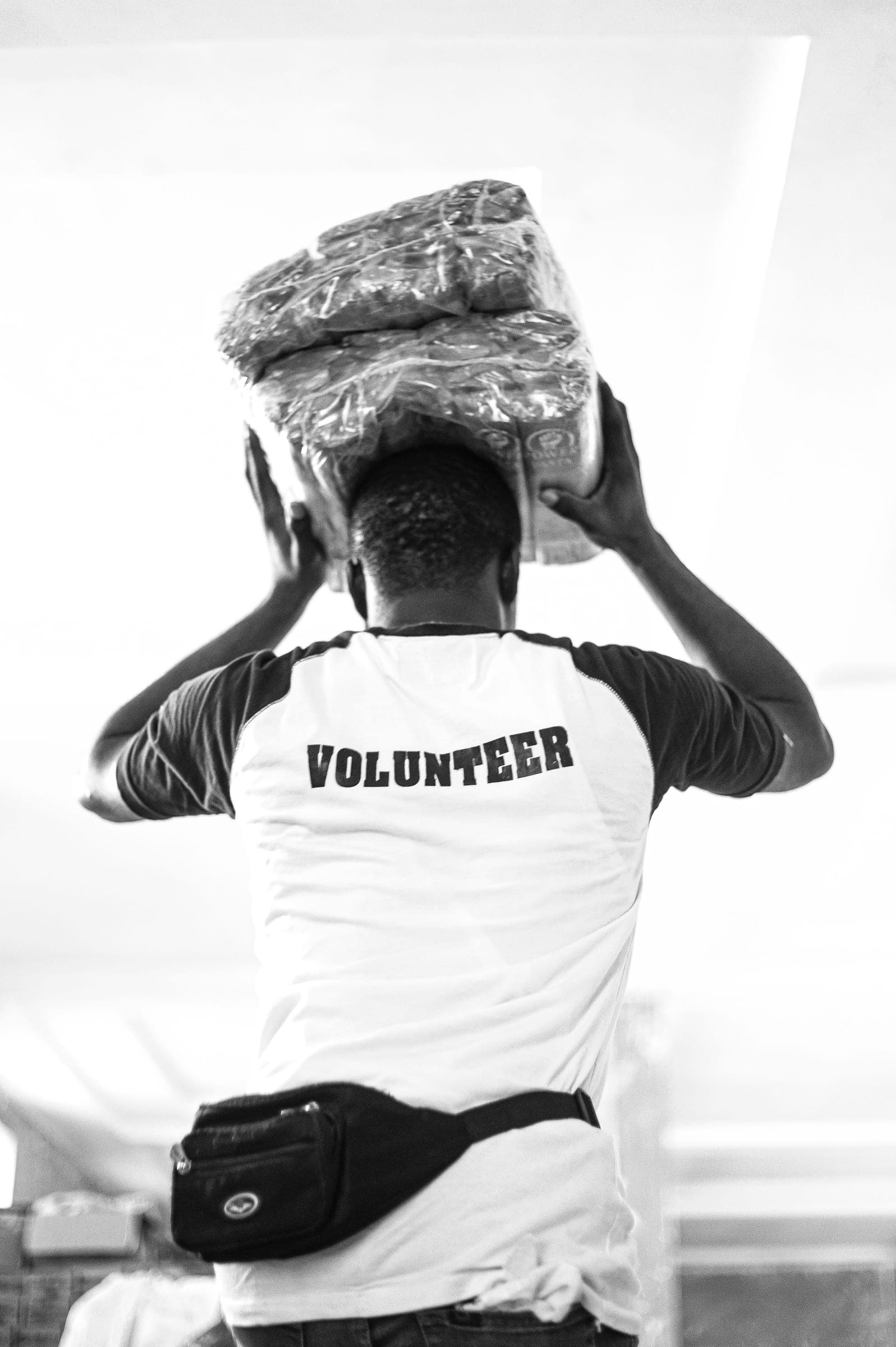 A volunteer carrying a package of supplies on his head
